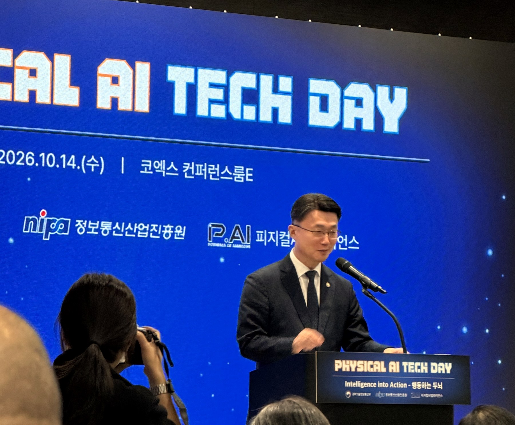 피지컬 AI 테크 데이 무대와 연단, 사진을 찍는 취재진